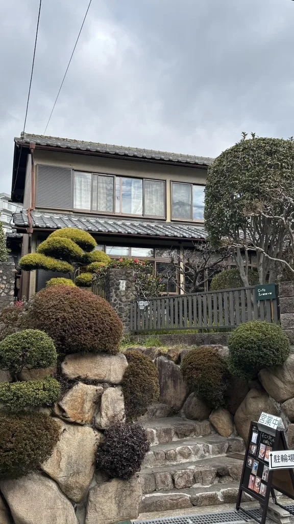石垣と庭木に囲まれた Cafe Bowwow の外観